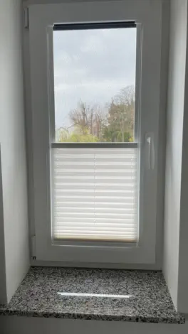 Komplettfenster-Plissee (hell, halb geöffnet)